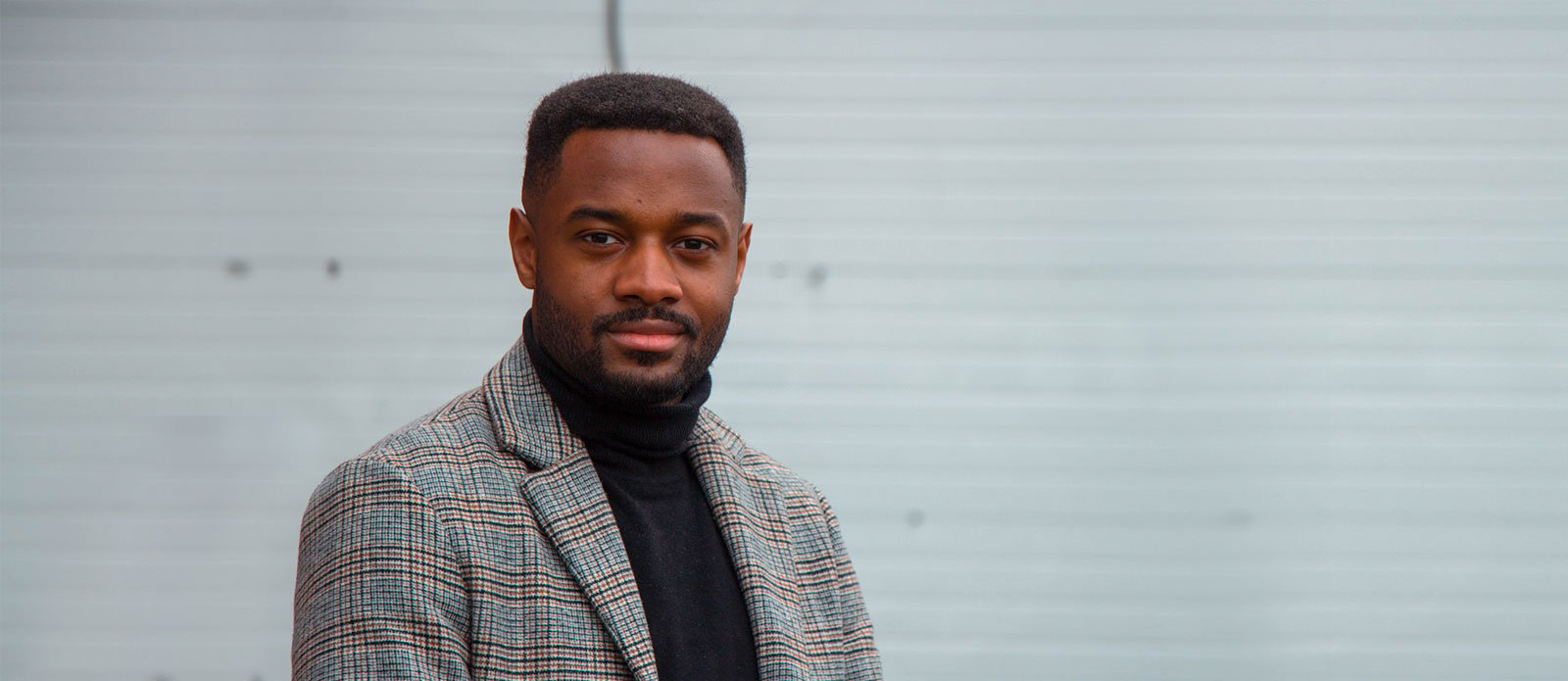 Black college-age professional in a suit jacket.