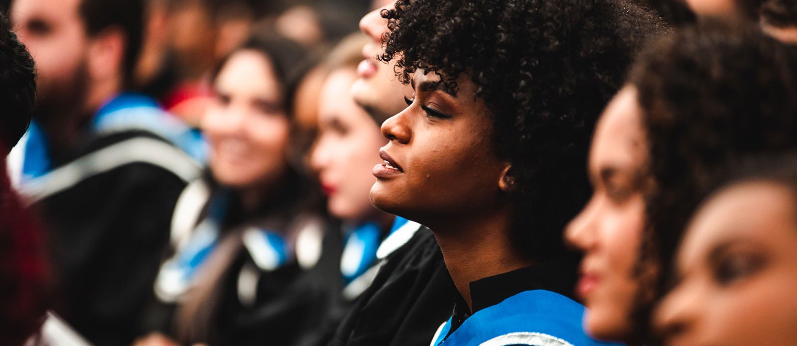 The impact of COVID-19 on Black students in Higher Education - Black Woman Sitting at Graduation with their Peers